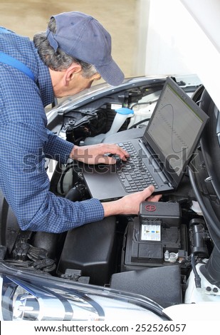A Car Mechanics with diagnostic notebook on car