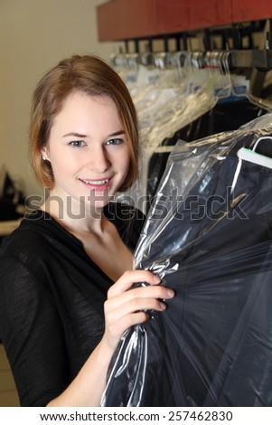A Woman in  Dry Cleaning with clothes packed in plastic foil