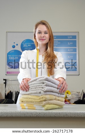 A Woman in dry cleaning with Towels on counter