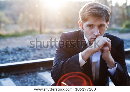 Portrait of young attractive man with suit in rail way