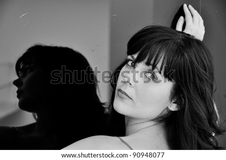 Beautiful woman reflected in a mirror in black and white