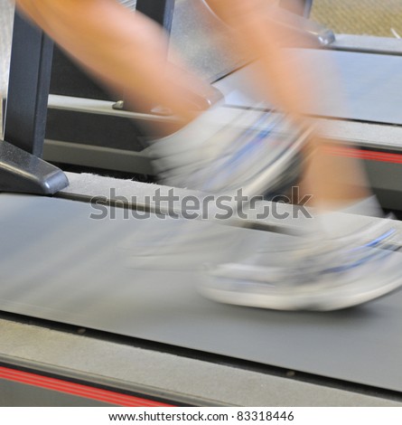 Shot on location an older male running on treadmill with very slow shutter speed.  The treadmill is clear and focus on,  athletes legs motion blurred.