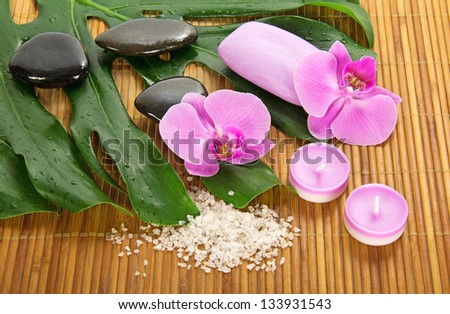 Monstera leaf, orchid and set for Spa on a bamboo cloth