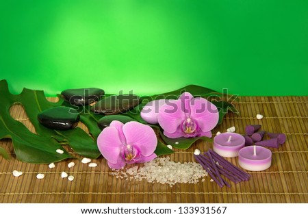 Orchid flowers, set for Spa on a bamboo cloth. Green background