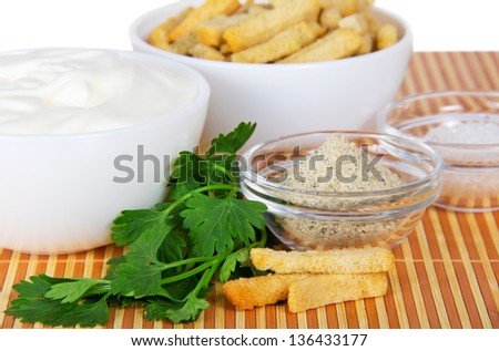 Sour cream, crackers and spices on a bamboo cloth, close up