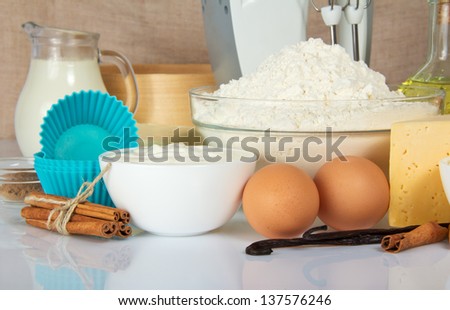 Eggs, sour cream, spices, a flour, cheese, a cake pan, on the beige