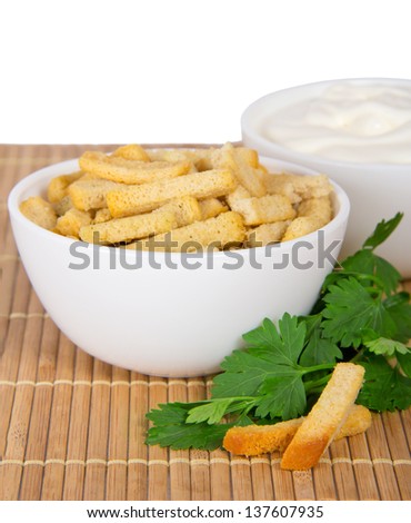 Cup with sour cream, a cup with croutons and parsley on the bamboo cloth, isolated on white