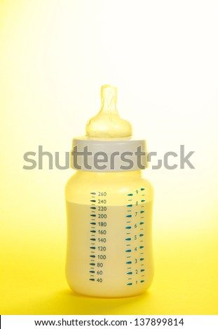 Small bottle for feeding of the child, on the yellow