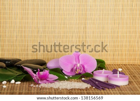 Flowers of an orchid and set for Spa on a bamboo cloth. Beige background