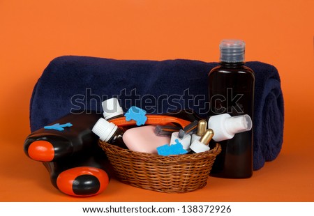 Big terry towel and basket with cosmetics on an orange background