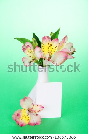 Pink alstroemeria in a vase and an empty card on the green