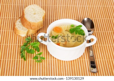 Transparent chicken broth with paste and vegetables on a bamboo cloth