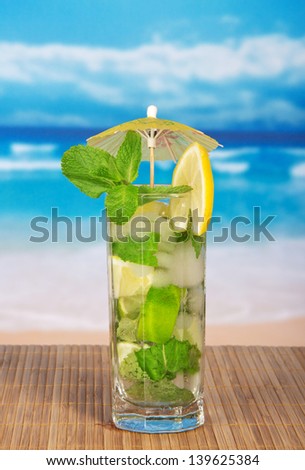 Mojito cocktail on a bamboo cloth, against the sea