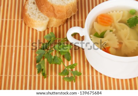 Transparent chicken broth with paste and vegetables on a bamboo cloth