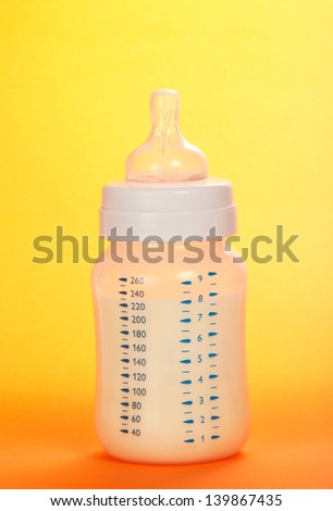 Small bottle for feeding of the child, on the orange