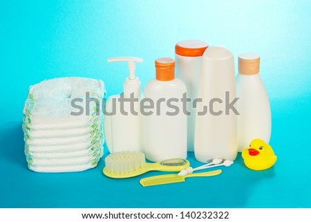 Baby care objects. Olive, shampoo, diapers on a blue background