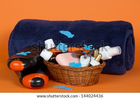 Big terry towel and basket with cosmetics on an orange background