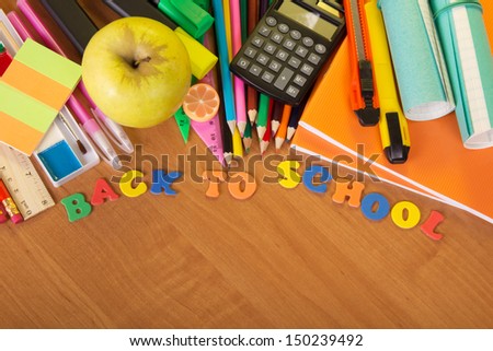 Exercise books, a big set of school tools the calculator and apple on a table