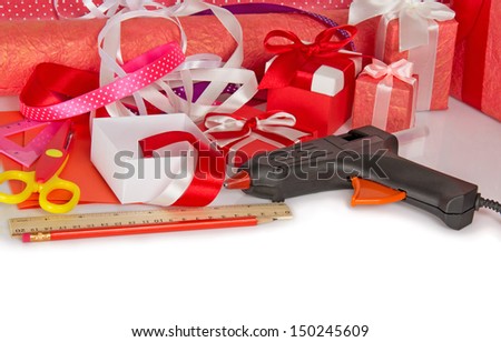 Gift boxes, paper rolls, scissors, ruler, pencil and the glue gun