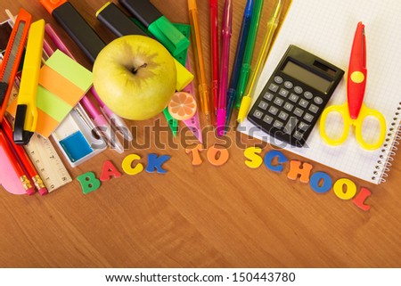 Blank exercise book sheets, a set for the letter and drawing, a calculator scissors and apple on a table