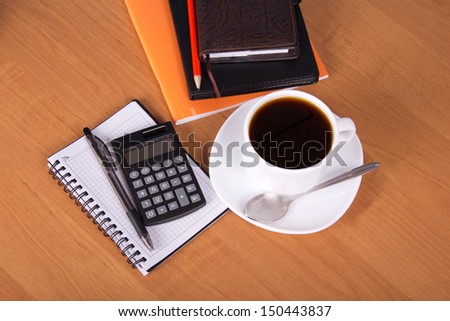 Notepad, organizer, empty sheets for notes, exercise book a pencil, the handle, the calculator, cup of coffee on a table
