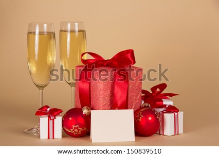 Christmas gifts and toys, champagne, an empty card on a beige background