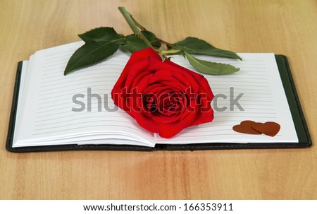 Open journal book with a red rose