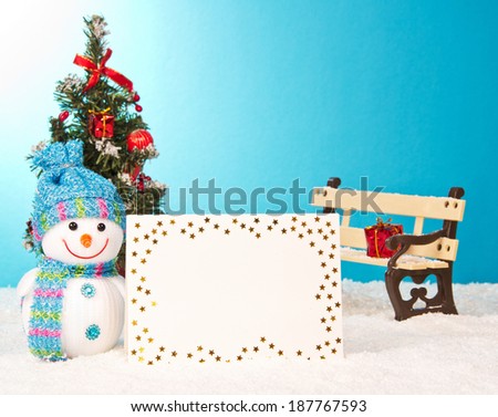 christmas tree with snowman and postcard on blue background