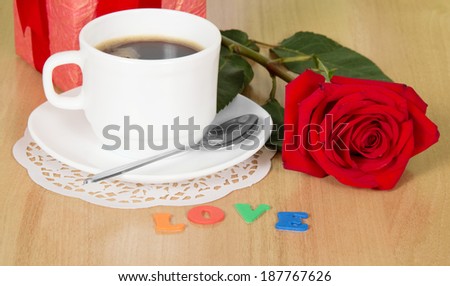 coffee cup and red rose on the table