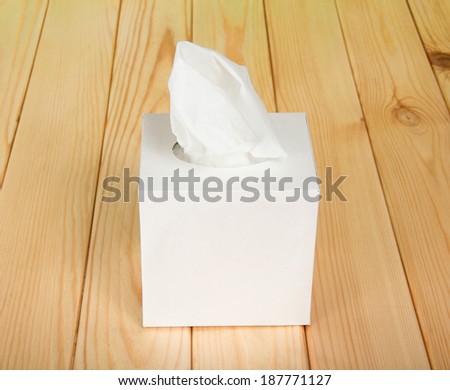 White box with napkins on wooden table