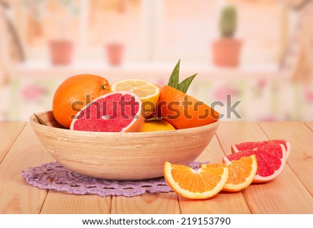 Bowl with different citrus fruits on kitchen table