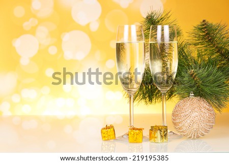 Two wine glasses with champagne on yellow background