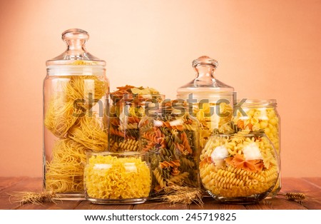 Uncooked italian pasta in glasses and jars