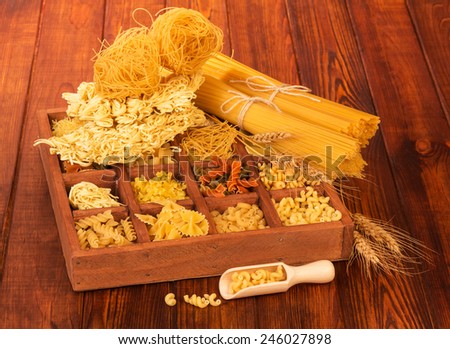 Bunch of raw spaghetti and pasta in wooden box