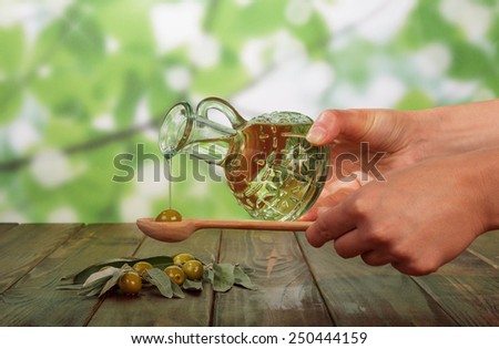 Olive oil in bottle and olives in hands