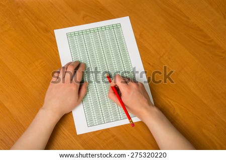 Above view of hands holding pencil over documents while working with papers