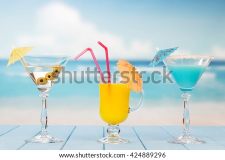 Martini glass with olives, drink and juice on the background of the sea.