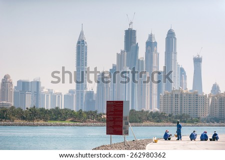 Dubai - 11 April 2012. Sea and high-rise buildings and  vacationers builders in Dubai in the background in Dubai