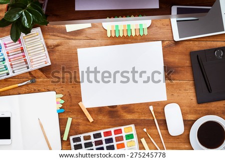 Desk of an artist with lots of stationery objects. Studio shot on wooden background.Top view.