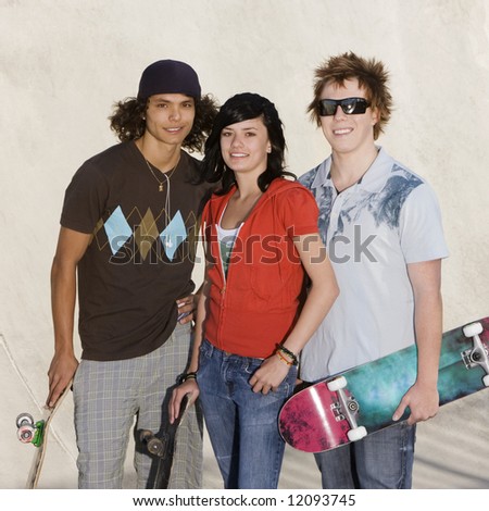 Three kids hang out at the skate park