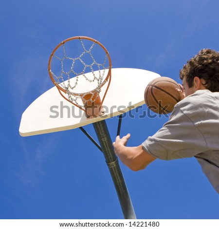Teen jumps to dunk a basketball