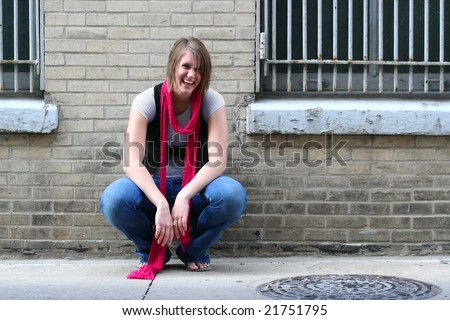 stock photo Girl squatting by wall