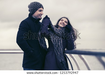 Happy young fashion couple in love having fun outdoor Stylish man and woman wearing classic coats beanie and scarf