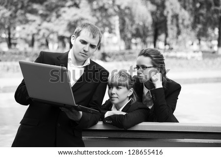 Young business people with laptop in a city park