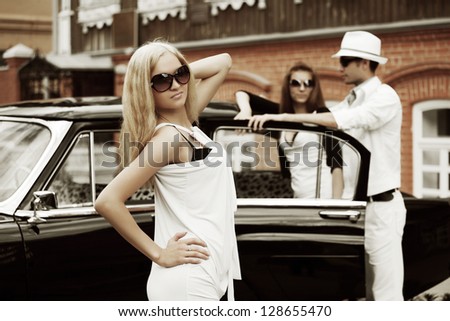 Young fashionable people with retro car