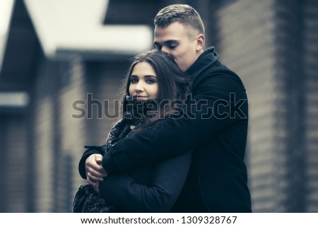 Happy young fashion couple in love embracing outdoor Stylish man and woman in classic coats