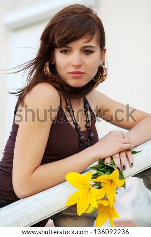 Sad young woman with a flowers