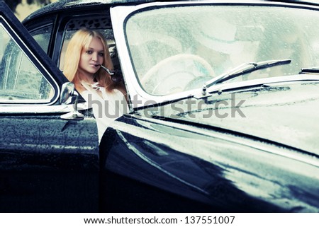 Young people driving retro car in the rain