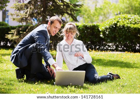 Young business people with laptop in a park