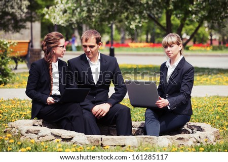 Business people with laptop in a city park